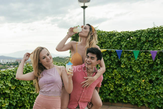 Group of friends having a pool party while they dance, laugh and drink cocktails — Stock Photo