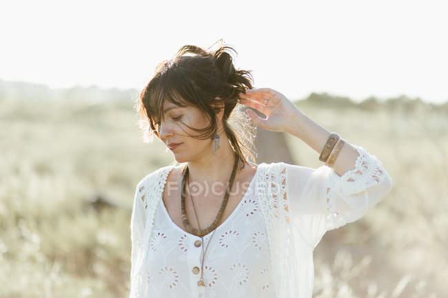 Портрет щасливої жінки в білому одязі, що стоїть на відкритому повітрі в денне світло — стокове фото