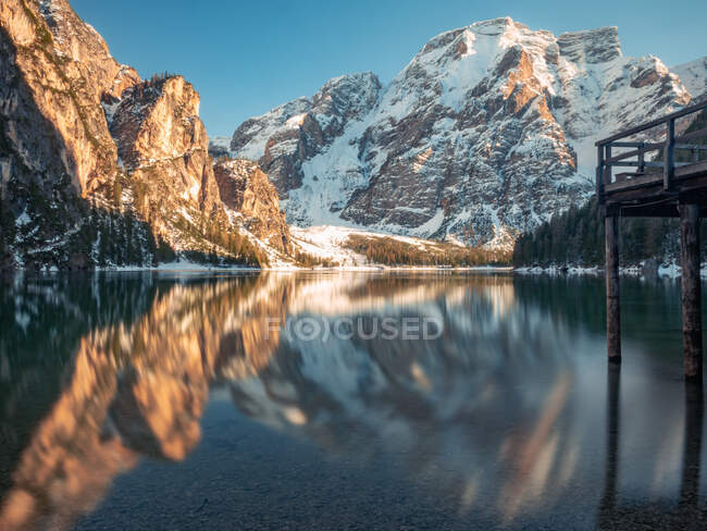 Impresionante paisaje con reflejo mágico de montañas rocosas en aguas cristalinas del lago en un día soleado brillante - foto de stock