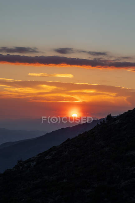 Picturesque view of majestic bright sundown above dark peaky cliffs — Stock Photo
