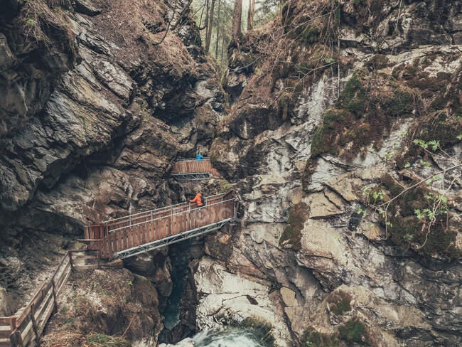 Caminante admirando la vista mientras camina por el camino entre la impresionante zona de montaña en Dolomitas, Italia - foto de stock