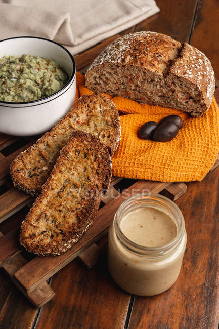 Смачні соуси, прикрашені кунжутом і пишним хлібом — стокове фото