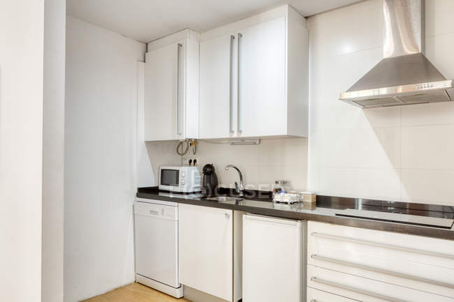 Interno di elegante cucina bianca vuota con elettrodomestici moderni e mobili — Foto stock