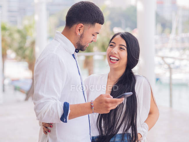 Jovem mulher atraente em roupas brancas com mensagens de texto homem no telefone móvel — Fotografia de Stock