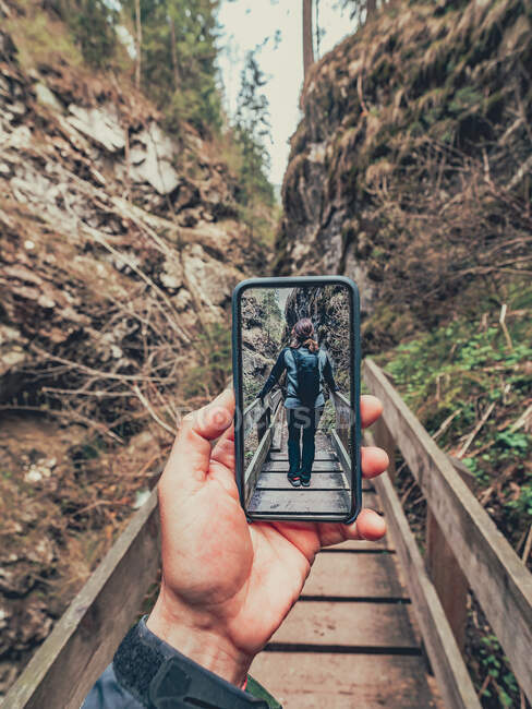 Traveller taking photo of hiker friend while walking on hiking footpath of picturesque area in Dolomites, Italy — Stock Photo