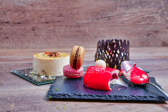 Serviert Mousse-Dessert mit bunten Makronen auf Schiefertafel — Stockfoto