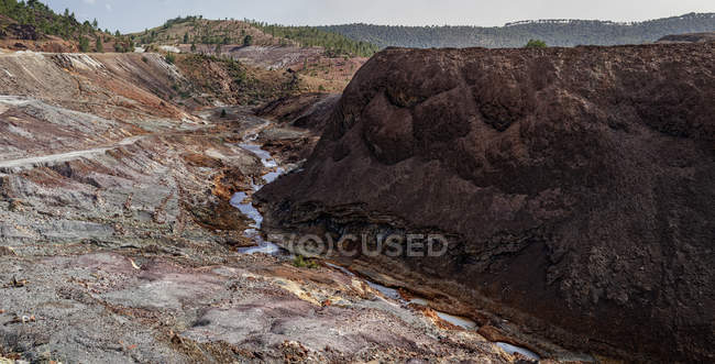 Cours d'eau traversant une vallée rocheuse à Riotinto — Photo de stock