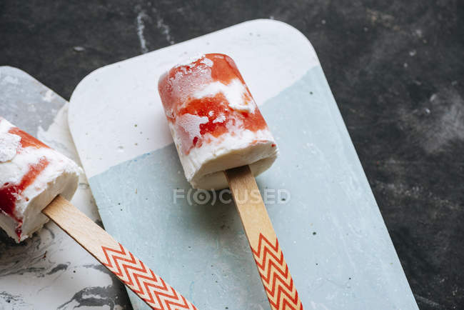 Two watermelon and cream popsicles on boards on dark background — Stock Photo