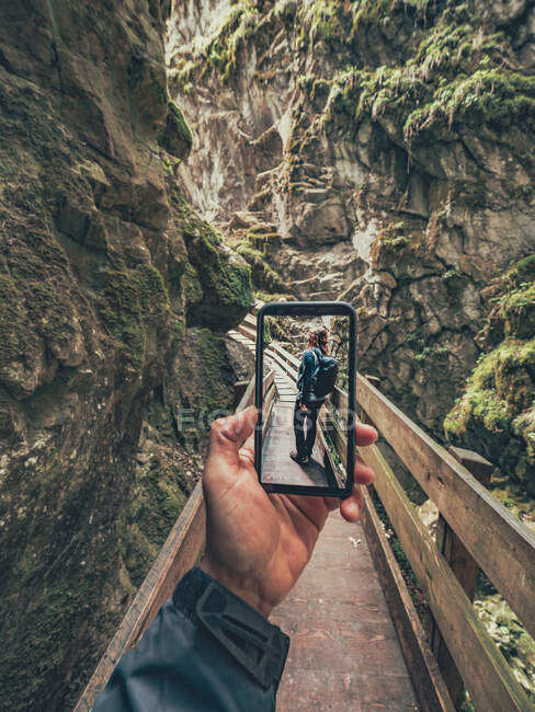 Путешественник фотографирует своего друга во время прогулки по пешеходной тропе живописного района Доломиты, Италия — стоковое фото