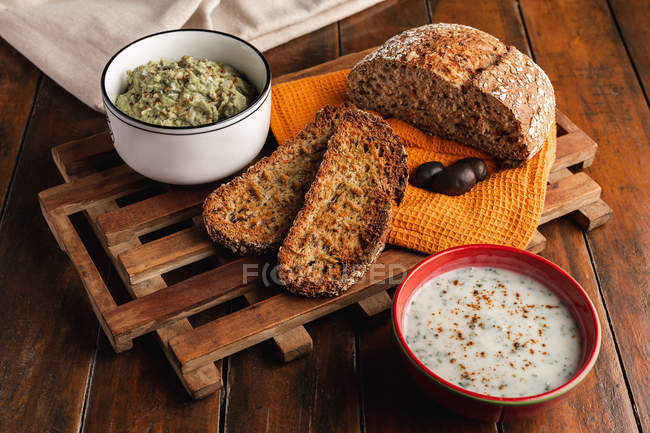 Смачні соуси, прикрашені кунжутом і пишним хлібом — стокове фото