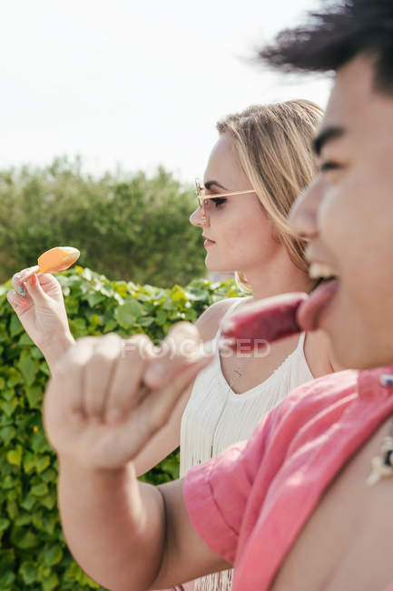 Des amis en train de manger de la crème glacée sur la terrasse d'un bar — Photo de stock