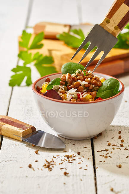 Сверху аппетитная красочная нарезанная овощная смесь со шпинатной чечевицей и рисом на деревянном фоне — стоковое фото