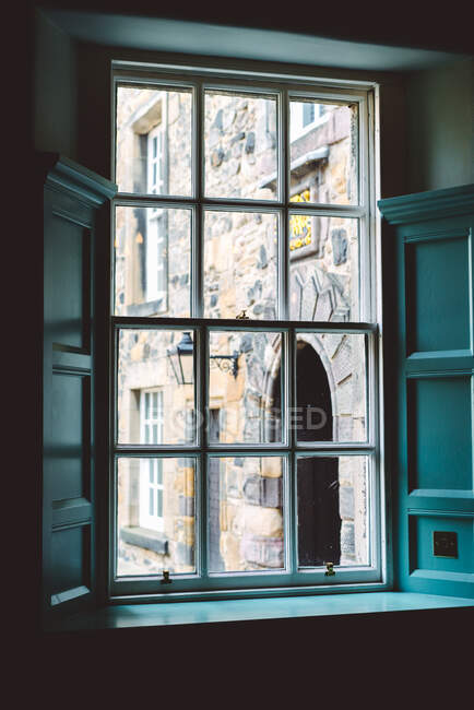 Blick durch alten Fensterrahmen mit gealtertem Steingebäude im weichen Tageslicht, Schottland — Stockfoto