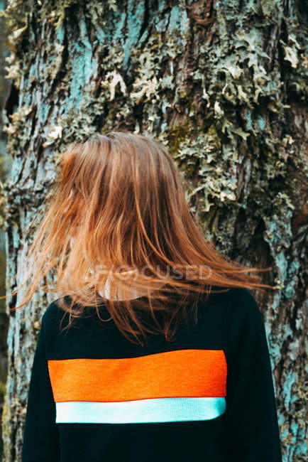 Belle jeune femme en sweat-shirt décontracté agitant les cheveux colorés au gingembre contre un vieil arbre, Écosse — Photo de stock