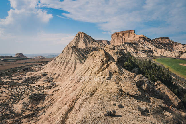 Захоплюючий пустельний пейзаж кам'янистих пагорбів на тлі хмарного блакитного неба — стокове фото