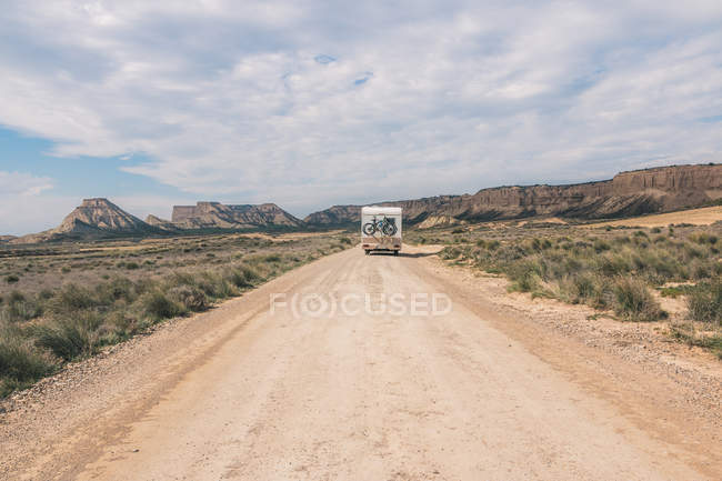 White trailer on empty road along desert — Stock Photo