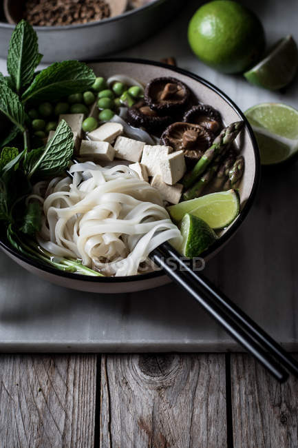 Served Pho soup with noodles on marble board on wooden table — Stock Photo