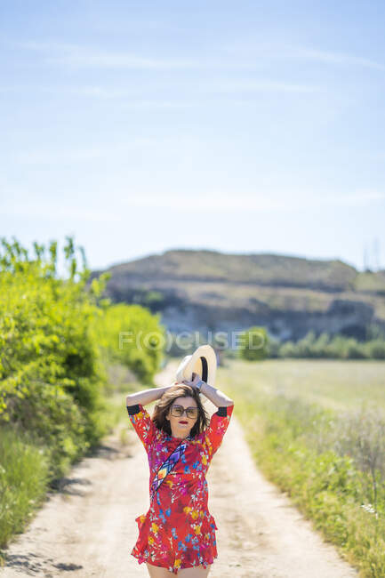 Mulher caminhando ao longo da estrada rural — Fotografia de Stock