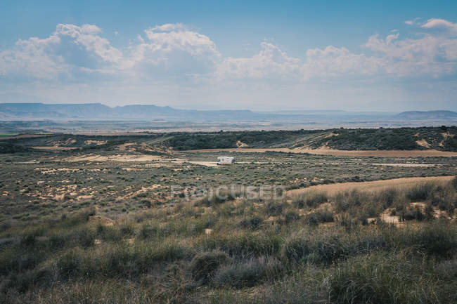 Білий трейлер на порожній дорозі вздовж пустелі — стокове фото