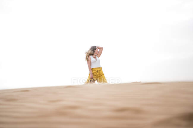 Fröhlich elegante blonde Frau mit Schuhen beim Wandern in der Wüste von Marokko — Stockfoto