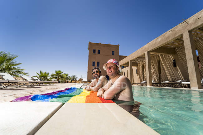 Счастливая гей-пара в бассейне — стоковое фото