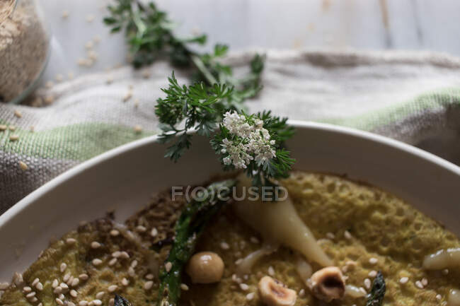 Vista superior da placa branca com crepe de aveia com espargos e pasta tahini servida em tábua rústica com verduras — Fotografia de Stock
