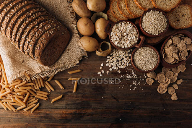 Comida integral y pan de centeno recién horneado en la mesa - foto de stock