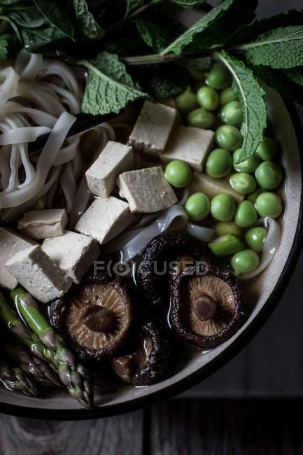 Closeup of served Pho soup with noodles on wooden table — Stock Photo