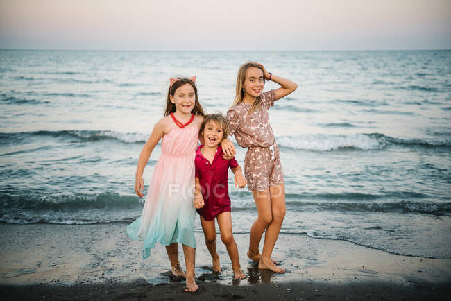 Grupo de garotinho com duas irmãs brincando em onda rasa de água na costa — Fotografia de Stock