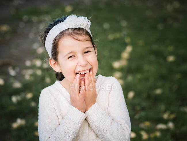 Portrait of adorable happy female kid looking at camera on background of summer park — Stock Photo