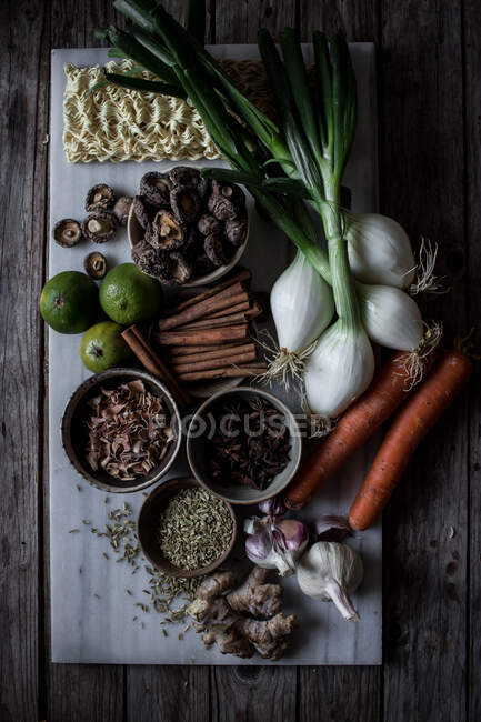 Von oben von Bord mit frischem Gemüse und Gewürzen mit trockenen Nudeln zum Kochen traditioneller Pho-Suppe — Stockfoto