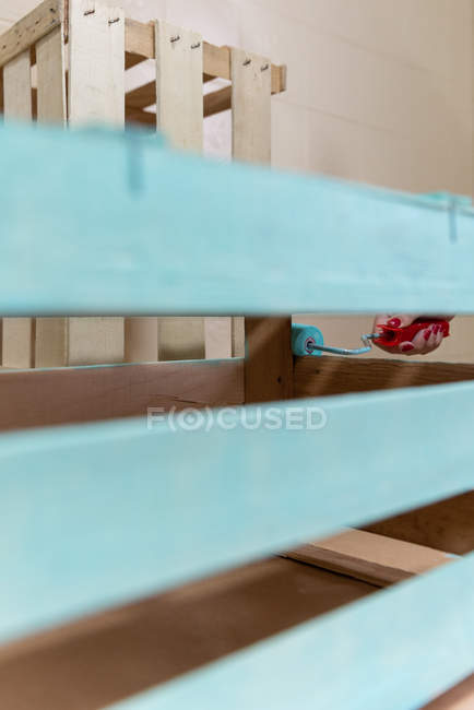 Close-up de mão feminina dor caixa de madeira na cor azul com rolo — Fotografia de Stock