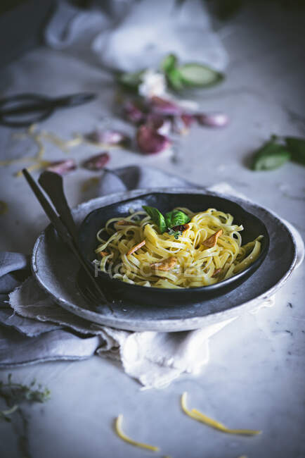 Dall'alto pasta appetitosa con basilico di verdure in boccia nera su tavolo servito — Foto stock