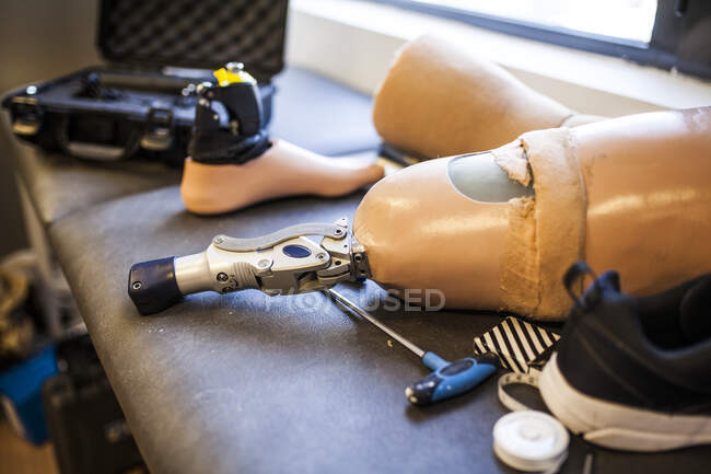 Неузнаваемый инженер-протезист рассматривает протез пациента и улучшает материал в его мастерской — стоковое фото