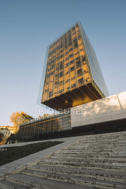 Stylish glass skyscraper reflecting sun in bright day in downtown — Stock Photo