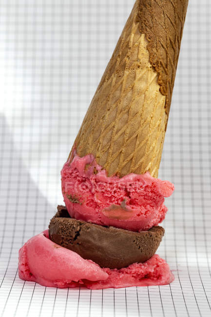 Ice cream cone dropped on graph paper — Stock Photo