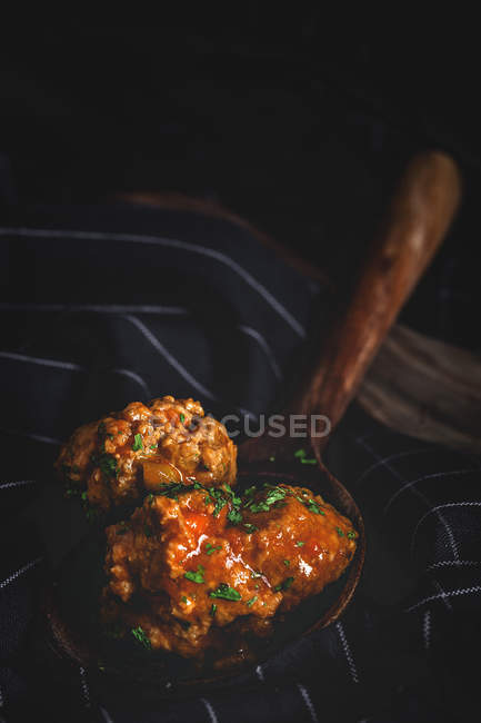 Par-dessus des boulettes de viande appétissantes en poche de bois brun sur serviette rayée noire — Photo de stock