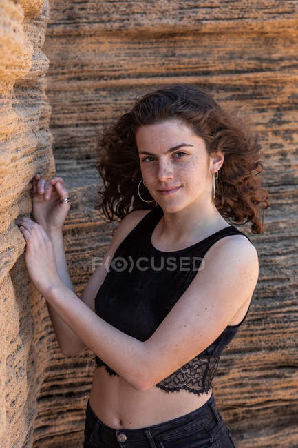 Portrait of slim woman in black crop top standing in canyon — Stock Photo