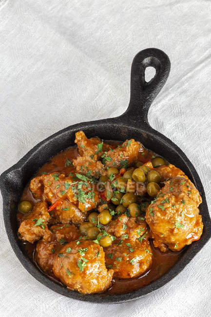 From above hot skillet with cooked delicious meatballs and green peas on white tablecloth — Stock Photo