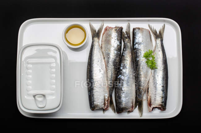 Pesce fresco lavato e squame senza teste su piatto bianco — Foto stock