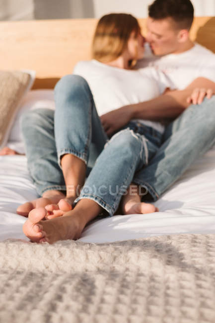 Joven pareja romántica en camisetas blancas y jeans acostados y abrazados  en el dormitorio de glamping — Inusual, Pasión - Stock Photo | #293866436