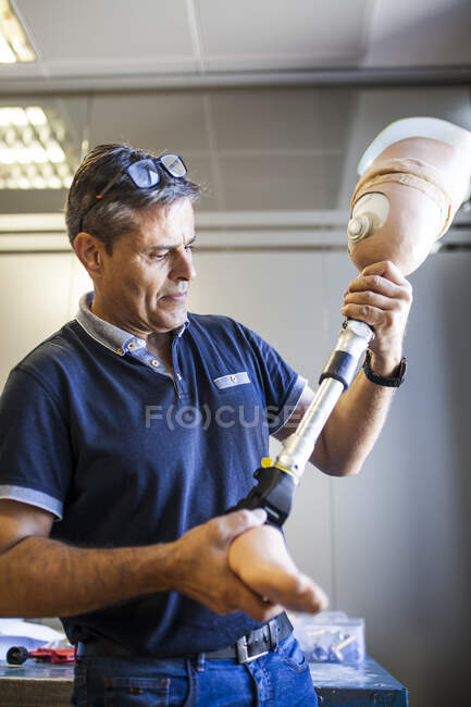 Ingegnere protesico che esamina la protesi di un paziente e migliora il materiale nella sua officina — Foto stock