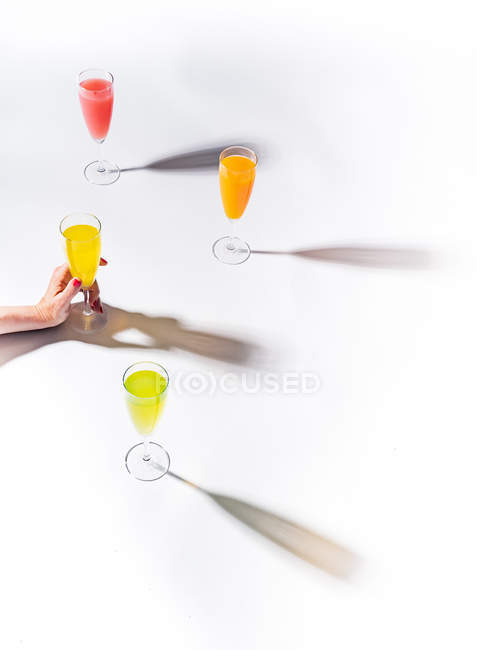 Female hand holding glass of glass of juice on white background — Stock Photo