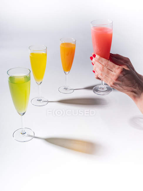 Vaso de mano femenina de jugo sobre fondo blanco - foto de stock