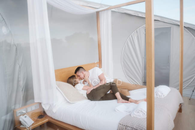 Casal apaixonado deitado na cama no hotel bolha — Fotografia de Stock