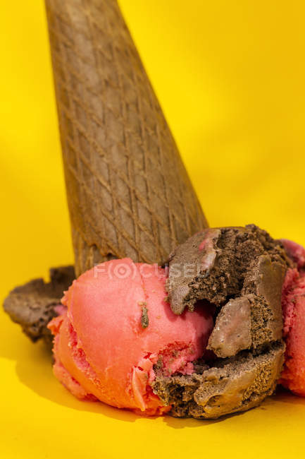 Ice cream cone dropped on yellow background — Stock Photo