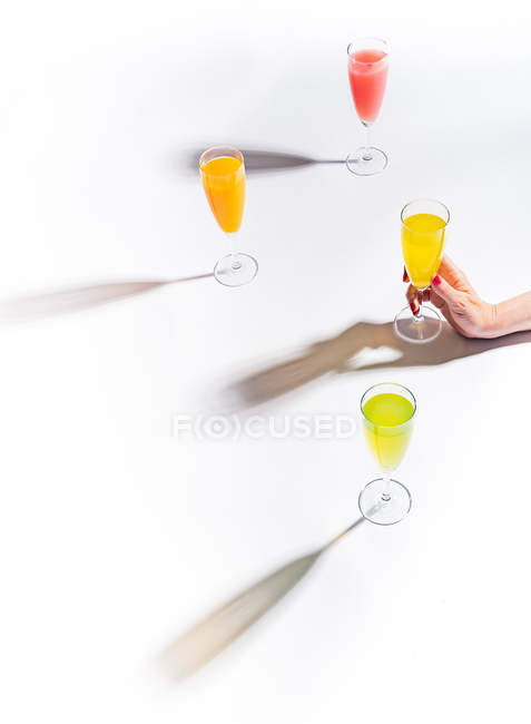 Женская рука держит стакан сока на белом фоне — стоковое фото