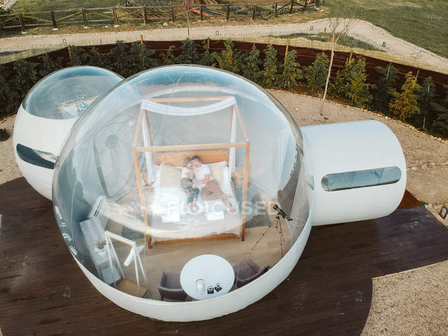 Drone vista de casal apaixonado deitado na cama em hotel bolha — Fotografia de Stock