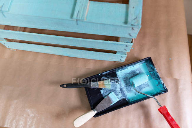 Caixa de madeira pintada na hora e ferramentas na mesa — Fotografia de Stock