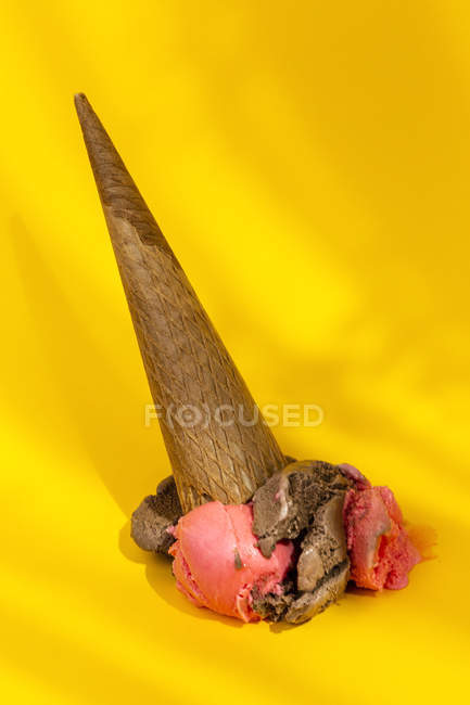 Ice cream cone dropped on yellow background — Stock Photo